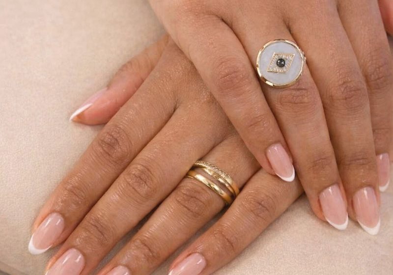 Elegant French tip manicure with gold jewellery at Serene Suite